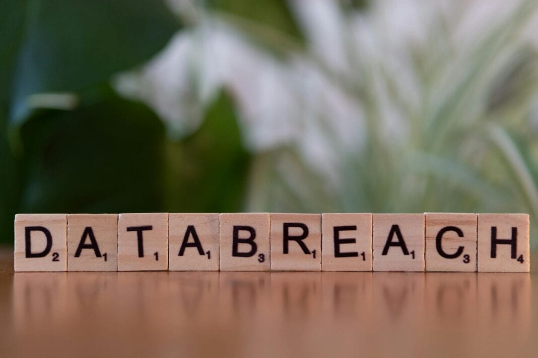 Klocki Scrabble układające się w napis data breach na rozmytym tle