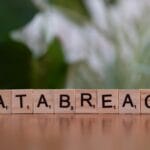 Klocki Scrabble układające się w napis data breach na rozmytym tle
