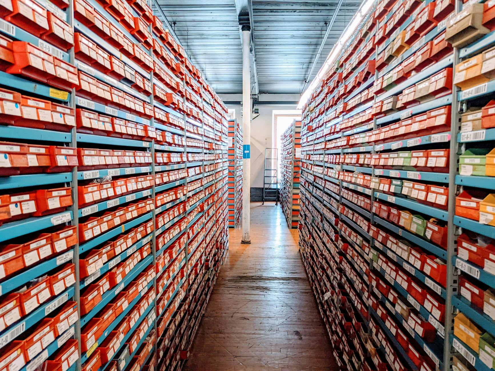 Regalne z czerwonymi pudełkami w uporządkowanej hurtowni obuwia