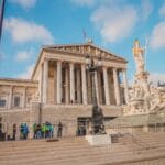 Jak powstaje prawo w Polsce: przewodnik po procesie legislacyjnym krok po kroku Budynek parlamentu w Wiedniu z fontanną Ateny i turystami przed wejściem