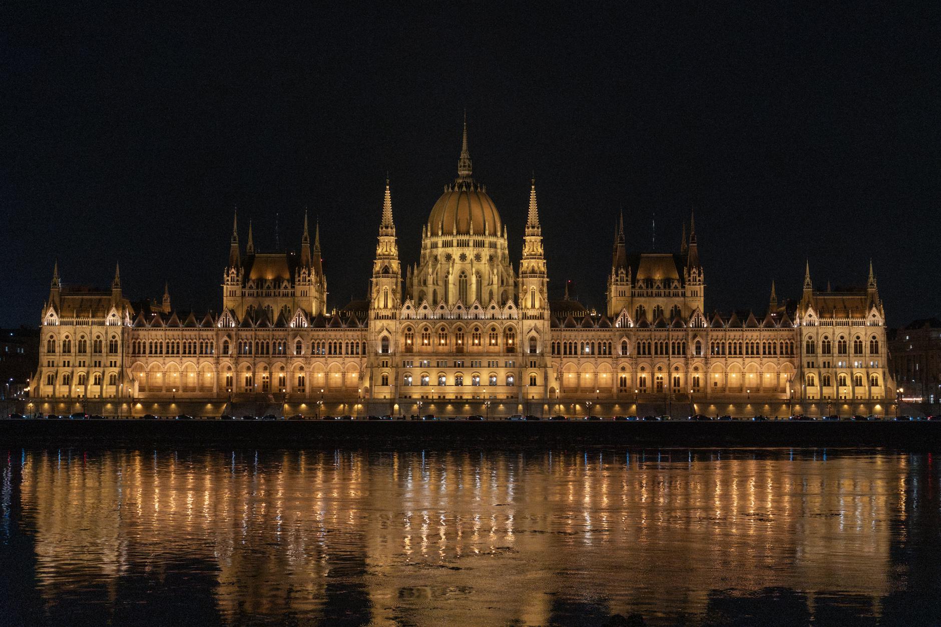 Nocny parlament w Budapeszcie odbijający się w wodach Dunaju