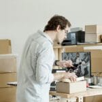 Przedsiębiorca pakuje buty do wysyłki w sklepie internetowym B2B