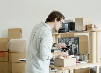 E-commerce B2B a obsługa zamówień niestandardowych: konfiguratory, zapytania i oferty online Przedsiębiorca pakuje buty do wysyłki w sklepie internetowym B2B