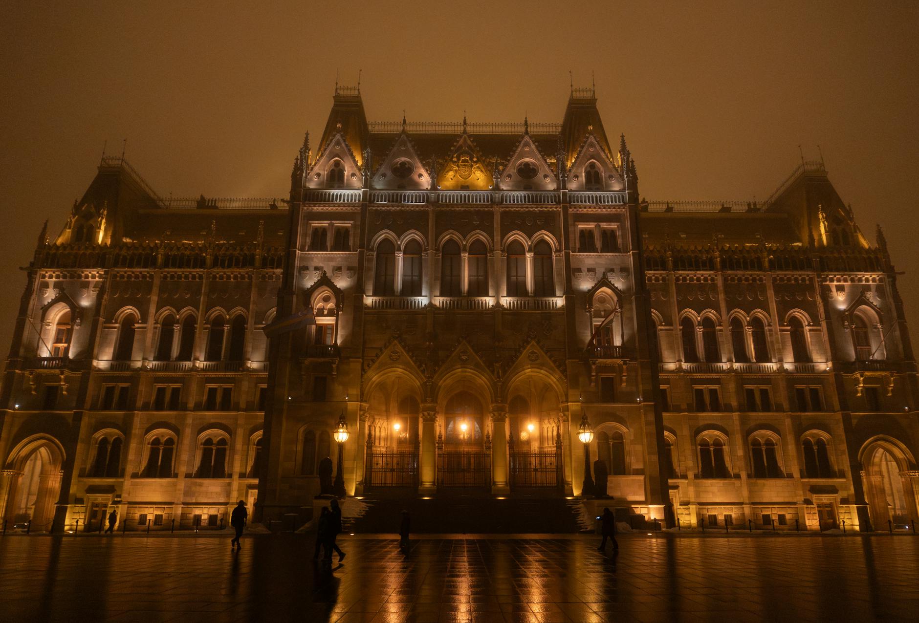 Węgierski parlament nocą we mgle, podświetlony nad Dunajem
