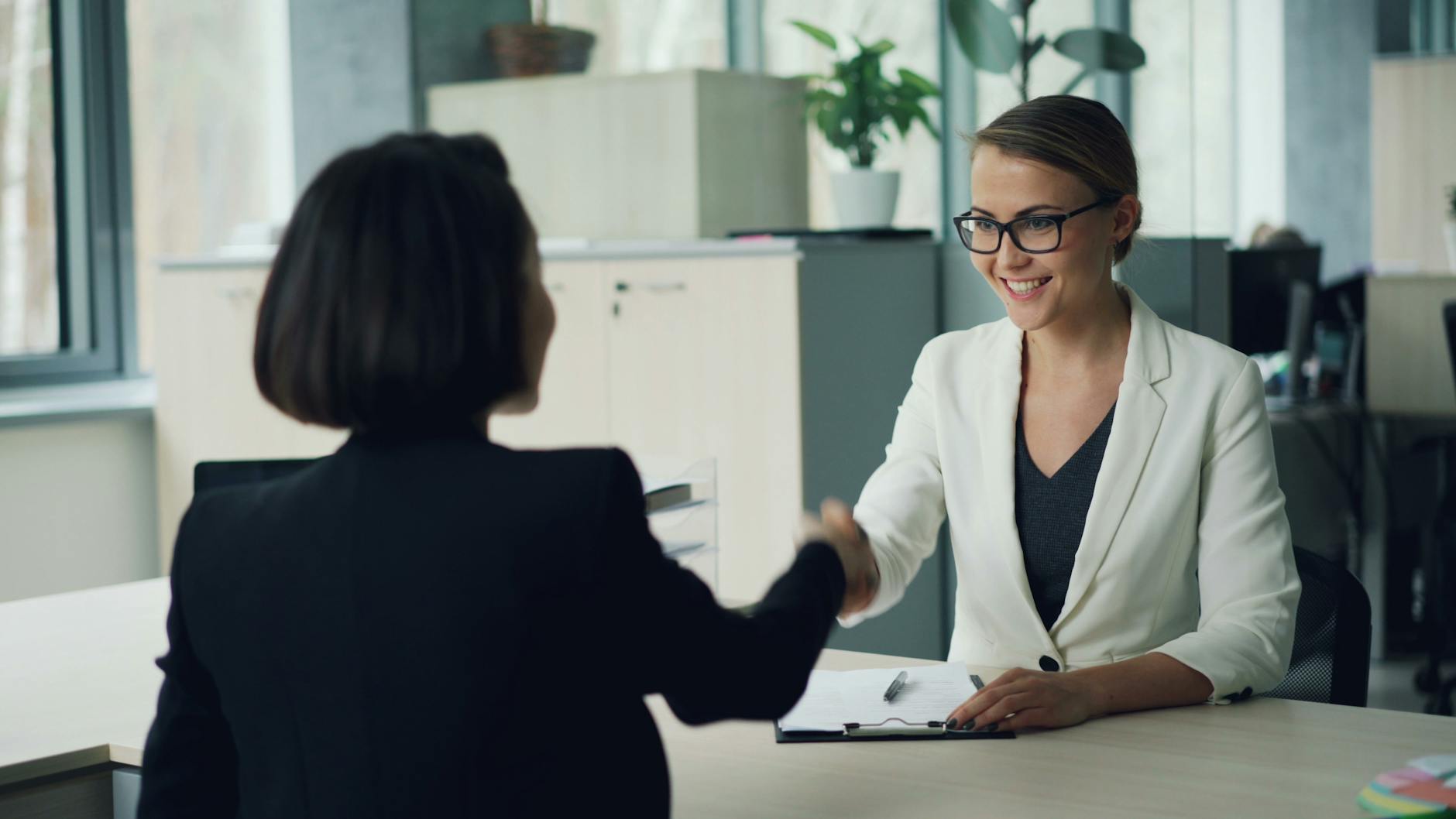 Dwie bizneswomen ściskają sobie dłonie w nowoczesnym biurze B2B