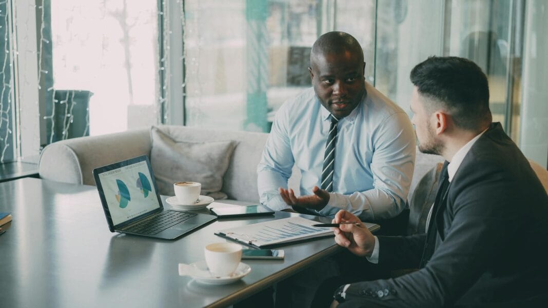 Dwóch specjalistów B2B omawia dokumenty przy laptopach Dwóch specjalistów B2B omawia dokumenty przy laptopach