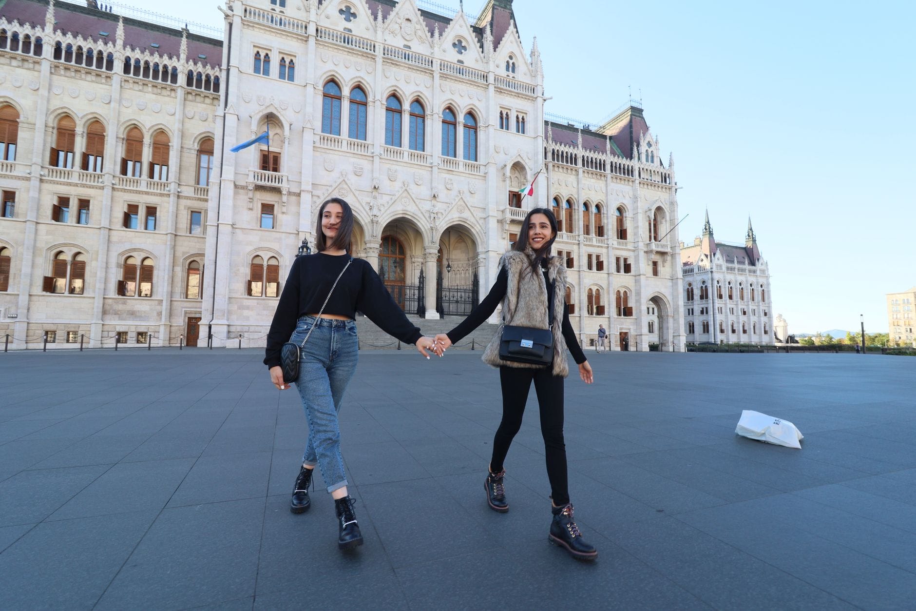 Dwie kobiety spacerują przed budynkiem parlamentu w Budapeszcie