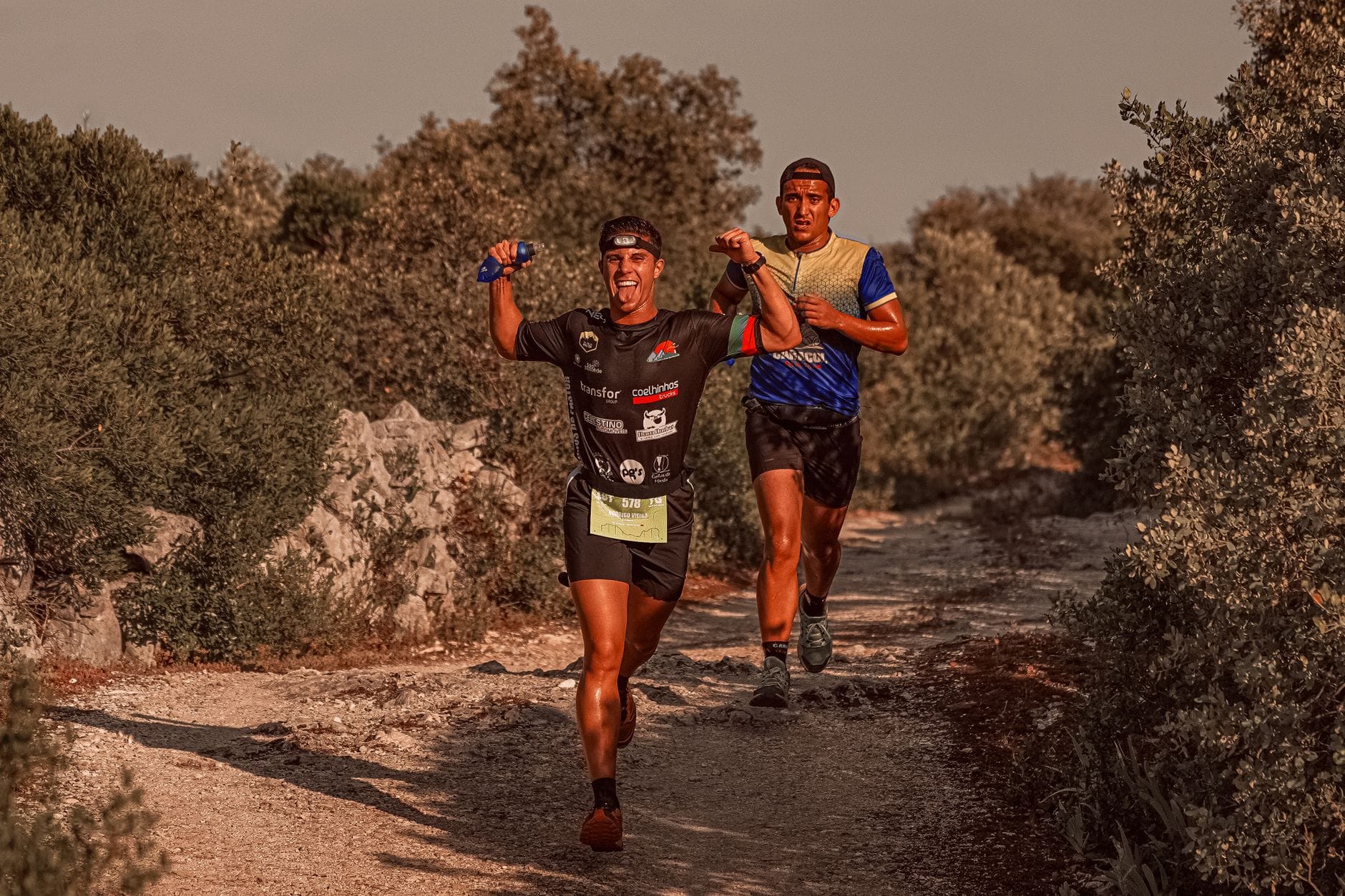 Dwójka biegaczy cieszy się podczas wiejskiego maratonu wśród krzewów