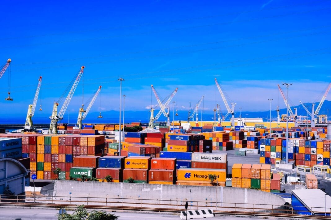 Ruchliwy port kontenerowy z dźwigami podczas załadunku towarów Ruchliwy port kontenerowy z dźwigami podczas załadunku towarów