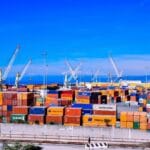 Ruchliwy port kontenerowy z dźwigami podczas załadunku towarów