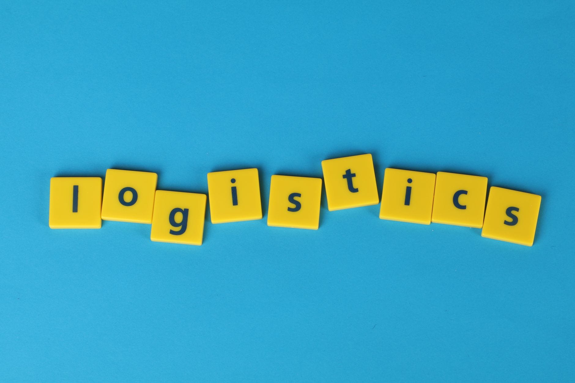 Żółte kostki z napisem logistics na niebieskim tle