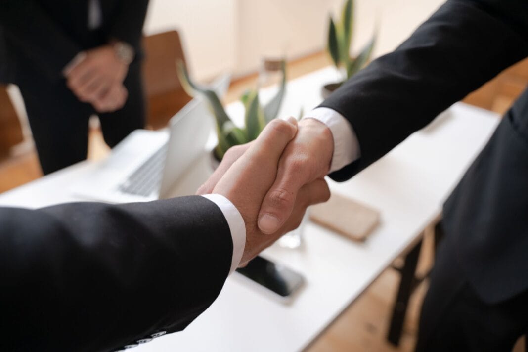 Uścisk dłoni dwóch profesjonalistów w biurze podczas ustalania ceny
